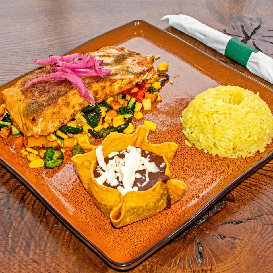Orale Mexican Restaurant's salmon dish with rice, vegetables, and a tortilla bowl of beans.
